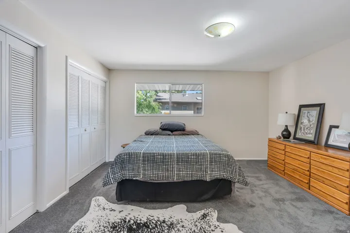 Dual bi-fold closet doors, wall-to-wall carpeting, recessed window, and flush mount lighting