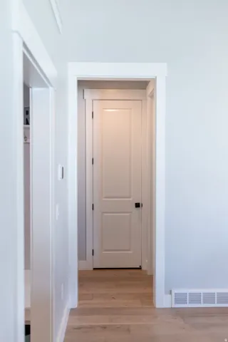 Wood-finish flooring with white trim and paneled interior doors