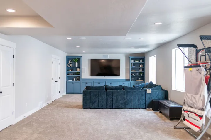 Recessed lighting throughout, built-in shelving, integrated cabinetry, and soft carpet flooring