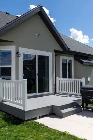 Exterior deck with composite decking, white railing, and dual steps