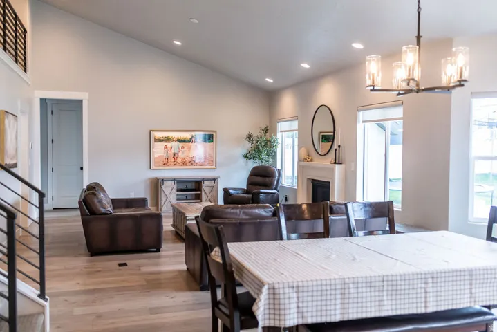 Vaulted ceilings, wood-finish flooring, recessed lighting, and a fireplace with a mantel