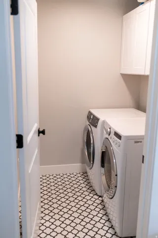 Patterned tile flooring, white shaker-style cabinetry, and light-toned wall paint