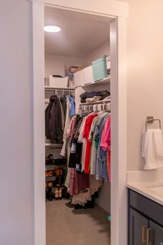 Walk-in closet featuring built-in shelving, hanging rods, and recessed ceiling lighting