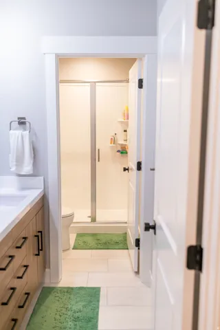 Light wood-finish vanity with drawer storage, white countertop, and integrated sink