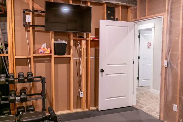 Home Gym with Custom Wood-Finish Built-In Cabinetry and StorageThis dedicated fitness space features custom wood-finish shelving and cabinetry with integrated storage for equipment