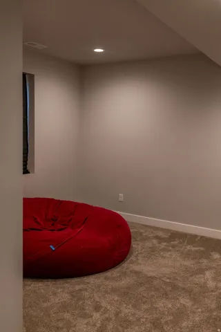 Recessed lighting, neutral wall paint, carpeted flooring, and white trim