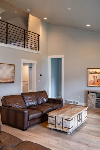 High ceilings with recessed lighting, wood-finish flooring, and a second-story open rail overlook