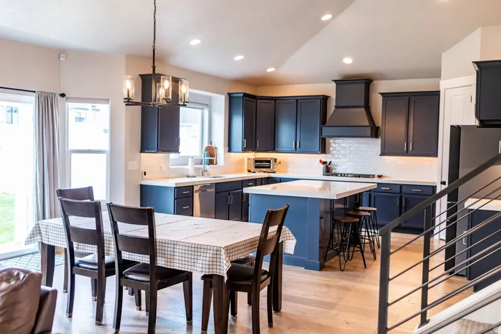 Kitchen featuring blue cabinetry, white countertops, a tiled backsplash, and stainless steel appliances