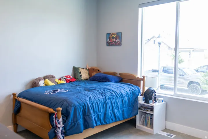 Large window with natural light, neutral wall colors, and carpeted flooring
