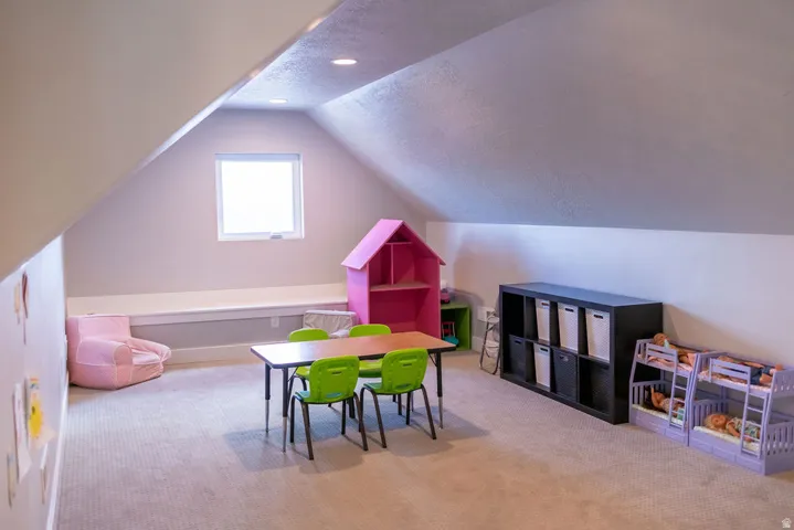 Attic space featuring sloped ceilings, recessed lighting, a built-in window bench, and an operable window