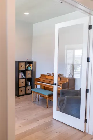 Recessed lighting, light wood-finish flooring, and a window with natural light