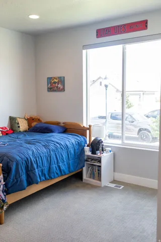 Recessed ceiling lighting, large window, and light grey wall paint