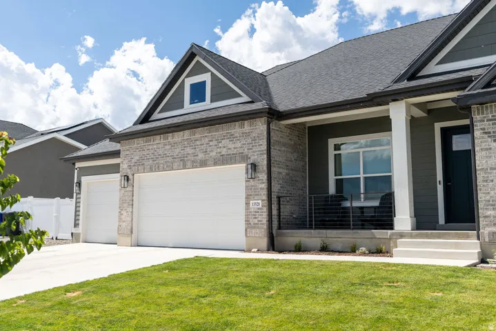 Exterior featuring light gray brick veneer, dark gray horizontal siding, and a dark asphalt shingle roof