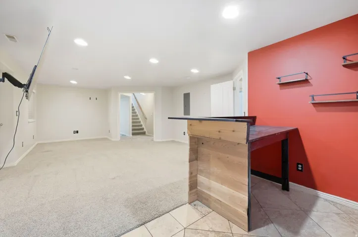 Recessed lighting, carpeted flooring, tiled flooring, wood-finish bar, staircase