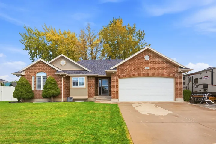 Brick exterior with a gabled roofline, an integrated two-car garage, and a concrete driveway