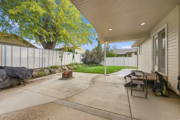 Expansive concrete patio with a covered section, recessed lighting, and direct access to the interior via a sliding glass door