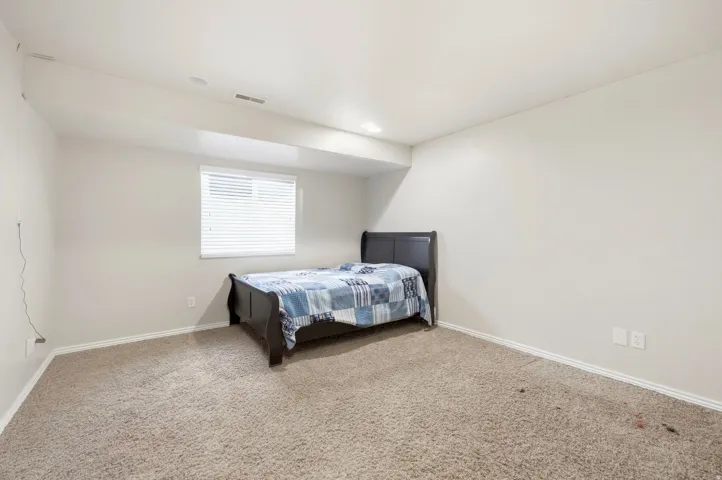 Recessed lighting, window with blinds, light-colored carpeting, white walls, and white trim