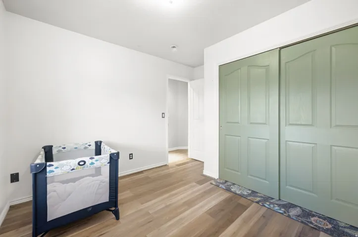Wood-finish flooring with light-toned walls and paneled closet doors