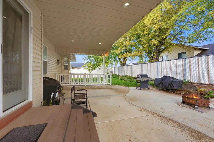 Covered patio with recessed lighting, concrete hardscaping, and a fully fenced yard