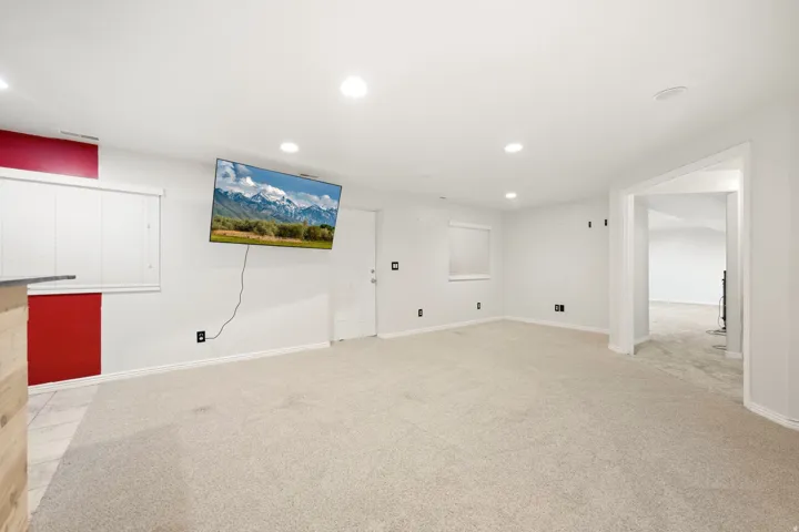 Recessed ceiling lighting, light-toned carpeting, and an open doorway