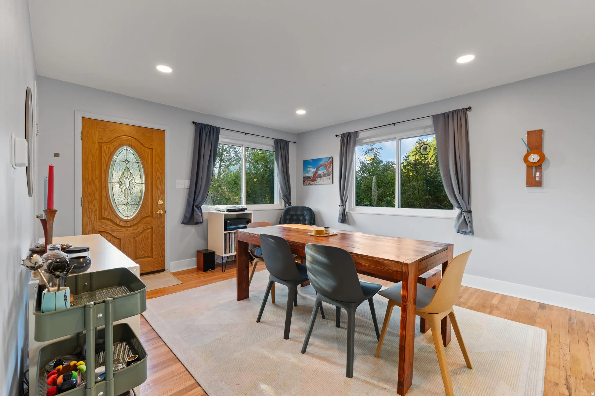 Wood-finish flooring, recessed lighting, and a leaded glass entry door