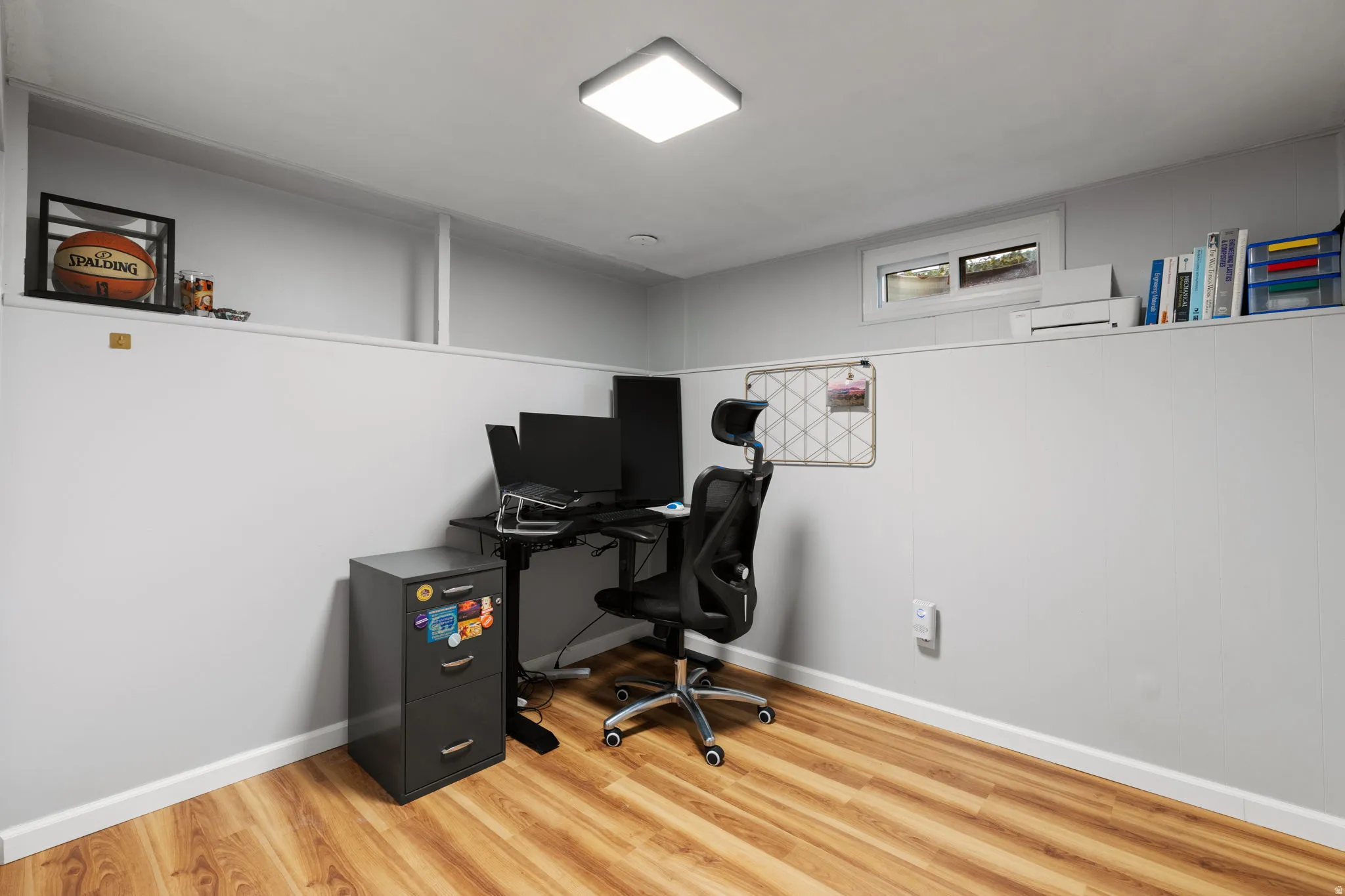 Wood-finish flooring with white baseboards, recessed ceiling lighting, and a horizontal window