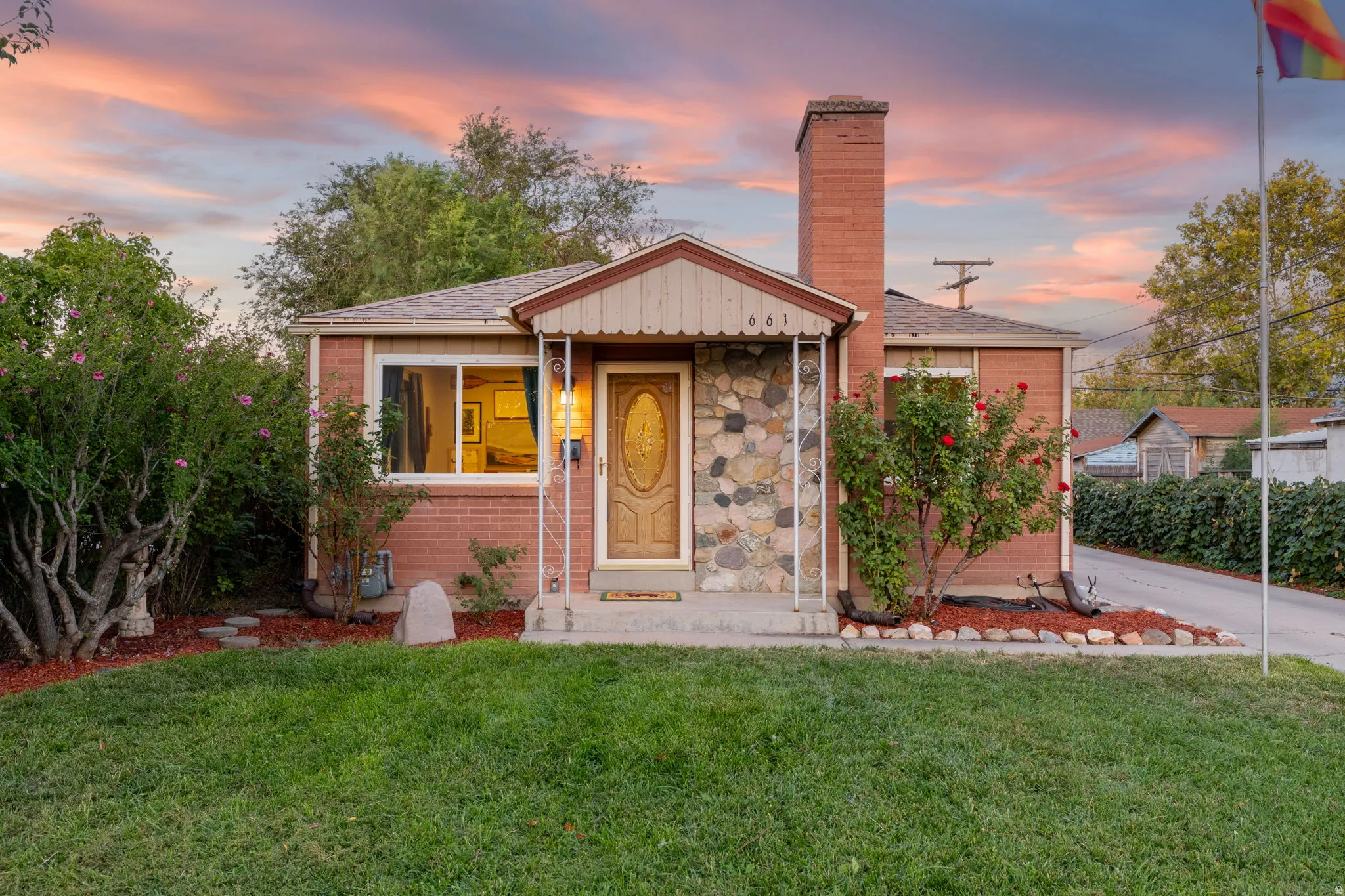 Brick exterior with stone veneer accents, an inviting front porch, and a prominent brick chimney