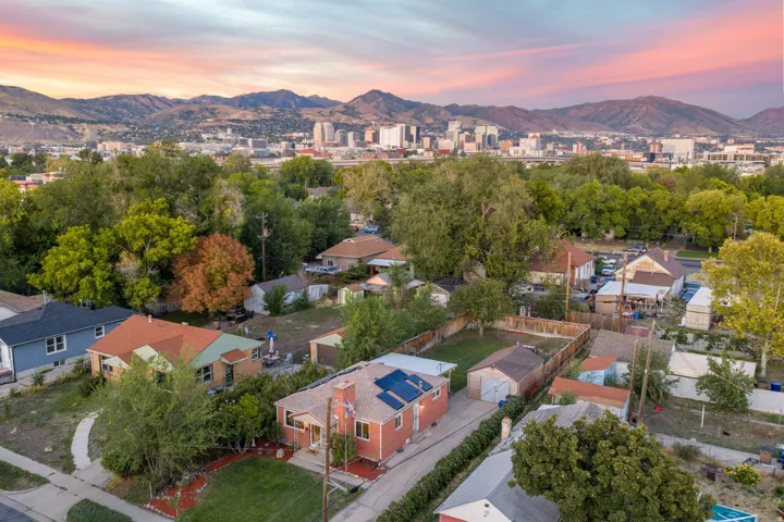 Residential neighborhood setting with mature trees and mountain backdrop
