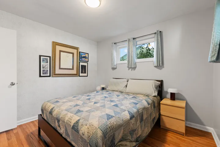 Hardwood flooring, two windows, and a flush mount ceiling light