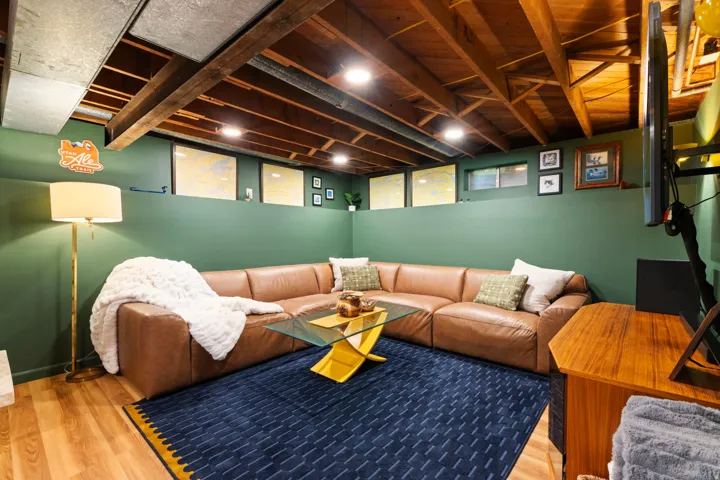 Exposed wood beam ceiling, recessed lighting, wood-finish flooring, and green wall accents