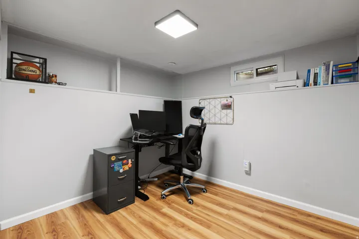 Wood-finish flooring with white baseboards, recessed ceiling lighting, and a horizontal window