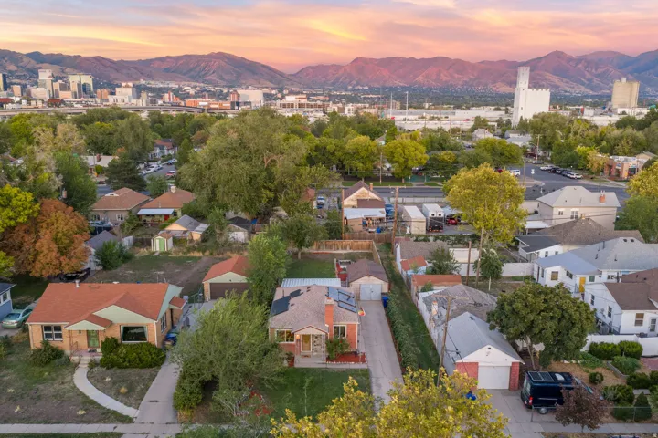 Aerial perspective featuring a residential neighborhood, mountain backdrop, and city skyline