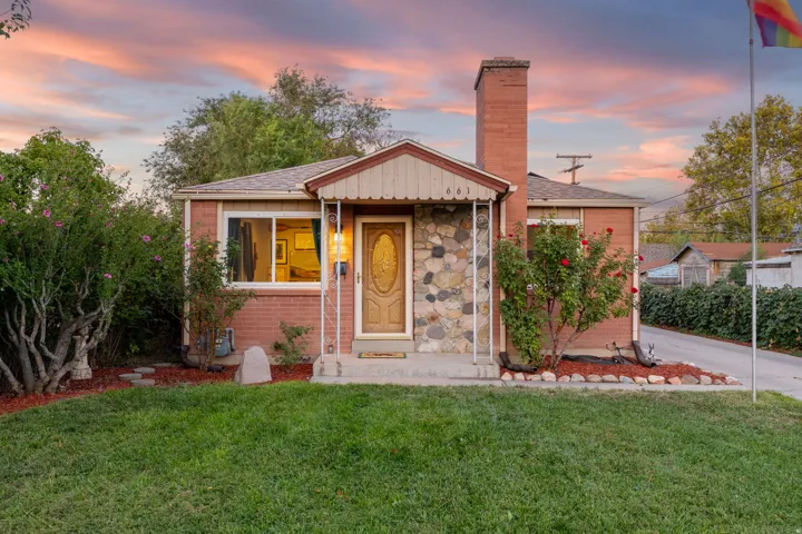 Brick exterior with stone veneer accents, an inviting front porch, and a prominent brick chimney