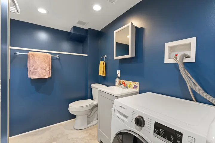 Recessed lighting, tile flooring, wall-mounted medicine cabinet, modern vanity with integrated sink, and a toilet