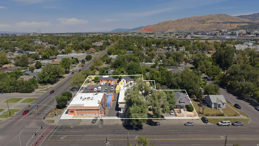 Mixed-use property featuring multiple buildings, surface parking, and mature trees