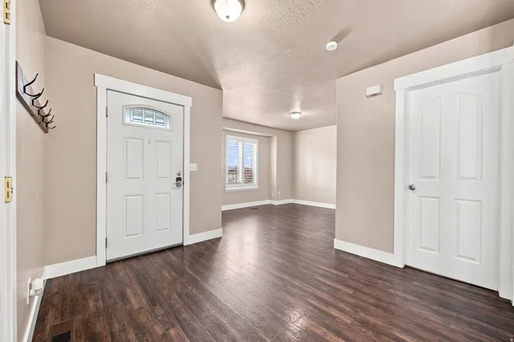 Wood-finish flooring throughout, white trim, and neutral wall tones