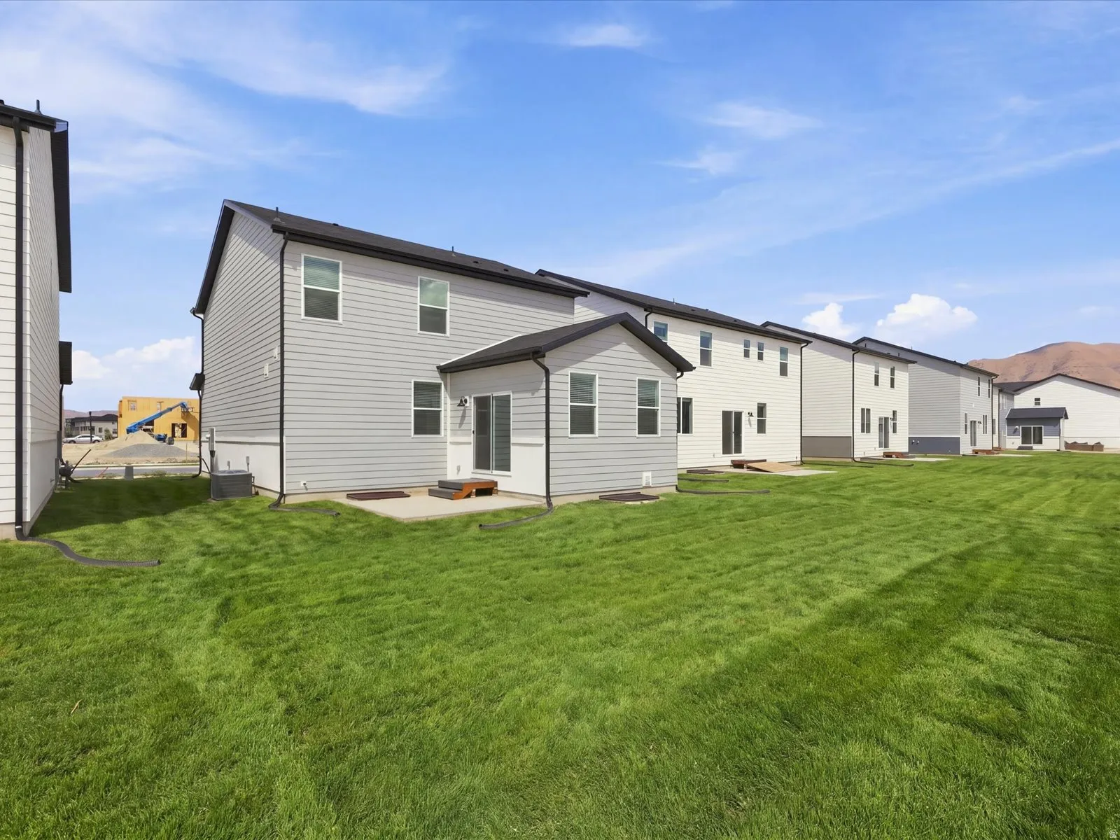 **DISCLAIMER** Landscape is only included in the front of the home. Expansive green lawn extending from the rear of the property, featuring a concrete patio