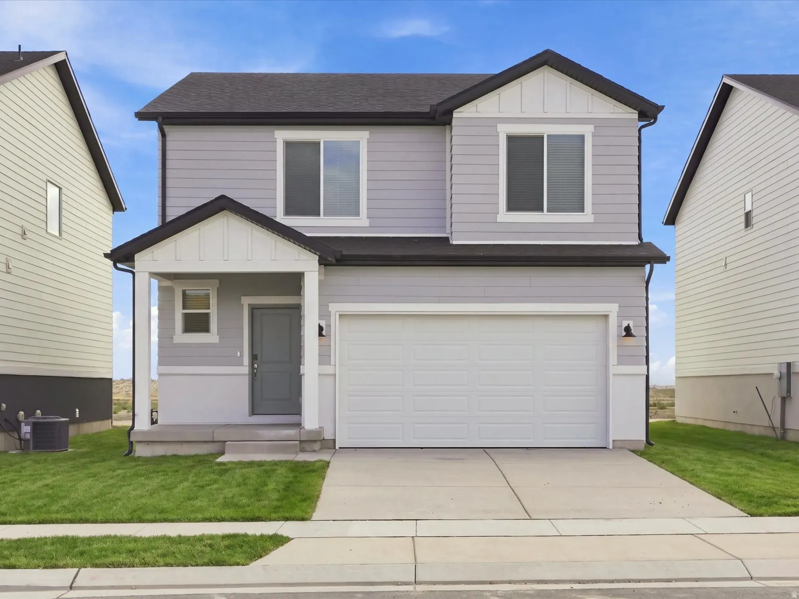 **DISCLAIMER** Elevation may vary on actual home. Two-story property featuring light gray siding, an attached two-car garage, and a covered front entry