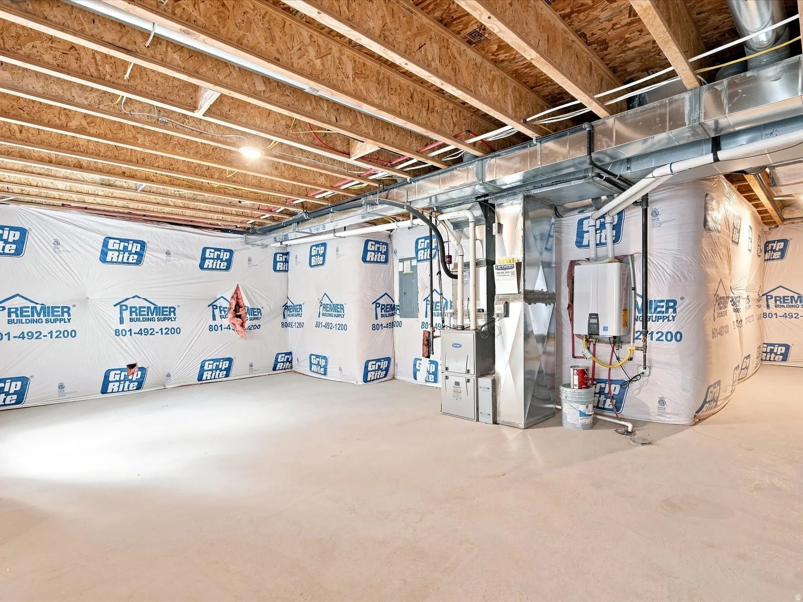 Unfinished basement with exposed ceiling joists and concrete flooring