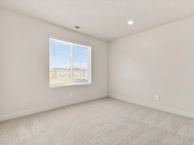 Recessed lighting, neutral wall paint, light-toned carpeting, and a window with blinds