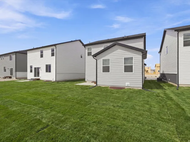 **DISCLAIMER** Landscape is only included in the front of the home. Expansive green lawn with a newly constructed exterior featuring light gray siding and black trim details