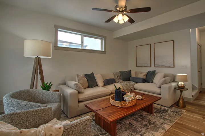 Recessed ceiling beam, wood-finish flooring, and a ceiling fan with integrated lighting