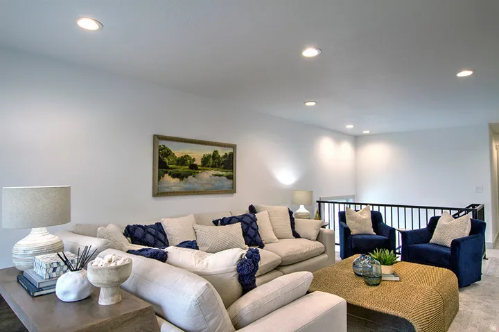 Recessed ceiling lighting illuminates this versatile common area featuring a wrought iron railing