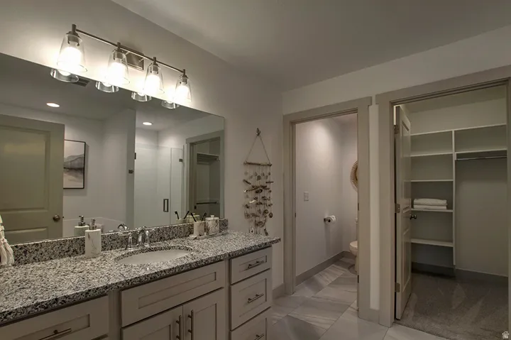 Vanity with a granite countertop, single undermount sink, and brushed nickel faucet