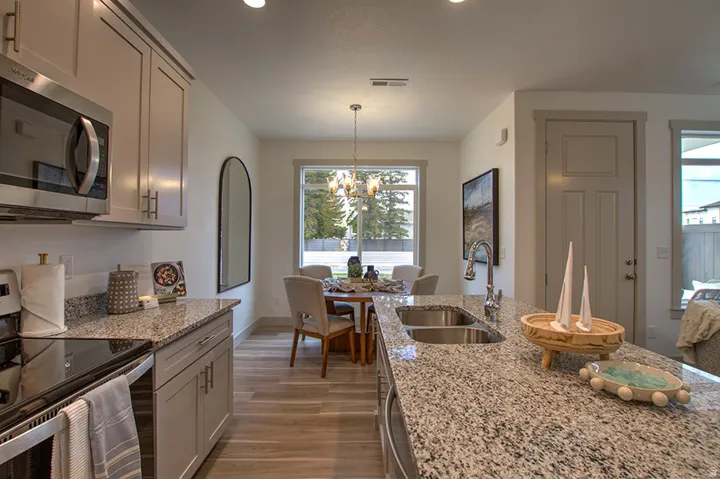 Kitchen featuring light gray cabinetry, stainless steel appliances, and speckled granite countertops
