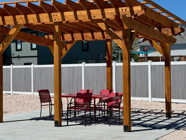 Expansive outdoor living area featuring a wood pergola over a concrete patio