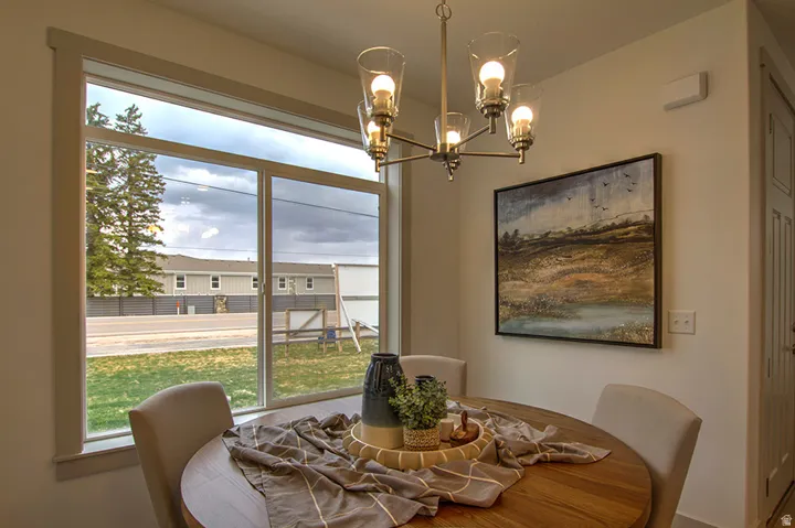 Expansive window with white trim, a multi-bulb chandelier, and a paneled door