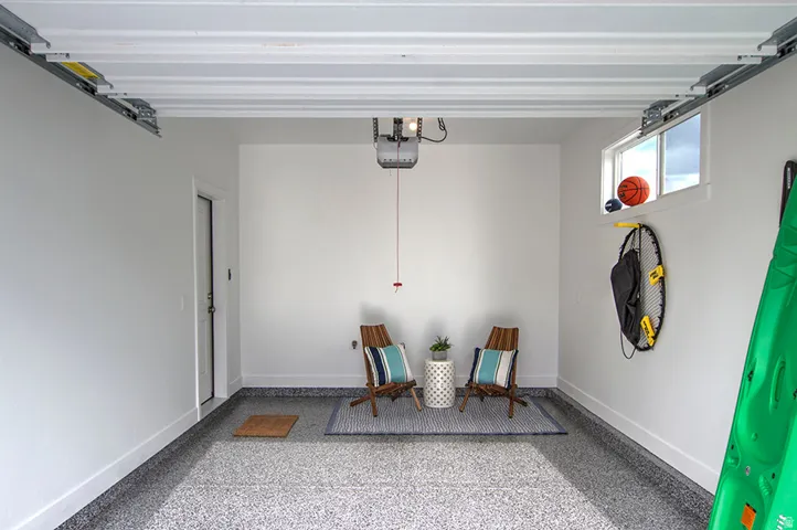 Finished garage space with an overhead door opener, a window for natural light, and durable epoxy flooring