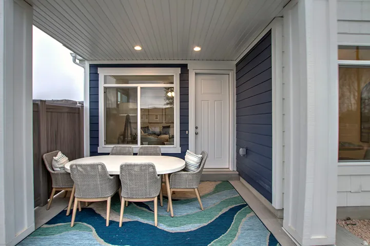 Covered patio featuring a white paneled ceiling with recessed lighting, blue horizontal siding, and white trim around windows and doors