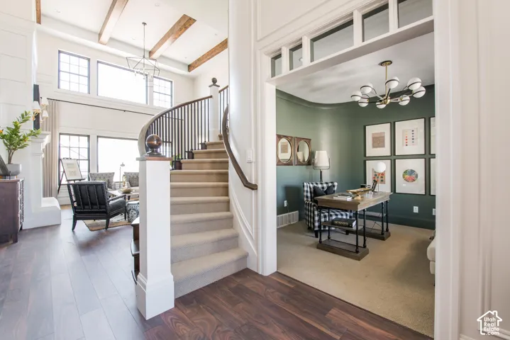 Two-story great room with exposed ceiling beams and a curved staircase